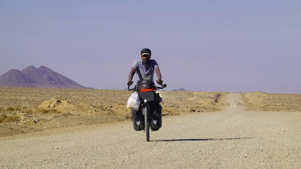 Marie und Asad mit Fahrrädern an der iranischen Grenze Freiradeln Wüste